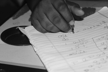 Hand of children holding pen writing on paper