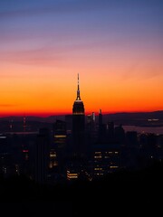 Obraz premium Distant city towers pierce the twilight sky, lights twinkling like scattered jewels, cityscape, evening