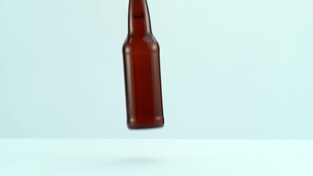 Bottle of beer falling and breaking in slow motion