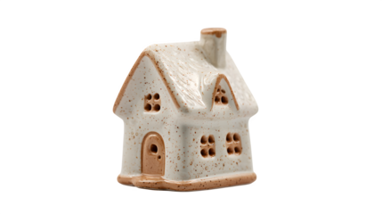 Charming miniature ceramic house with a speckled design and warm brown accents against a stark black backdrop creating a cozy and inviting feel
