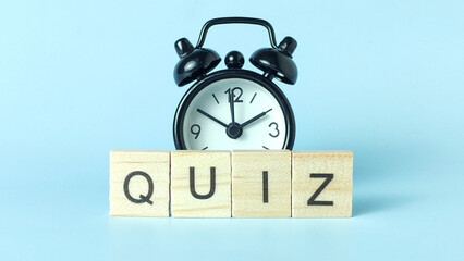 Wooden Blocks Spelling 'QUIZ' with an Alarm Clock Above Representing Test Deadlines, Educational...