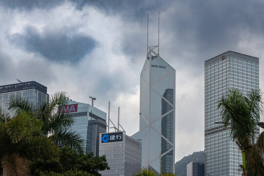 Bank of china tower rising above other buildings in hong kong with cloudy sky