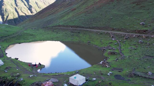 Chinar Lake in Surgan Valley showing camping tents and mountain backdrop near Noori Top