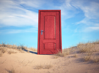 Colorful red door stands alone in a sandy landscape under a bright blue sky