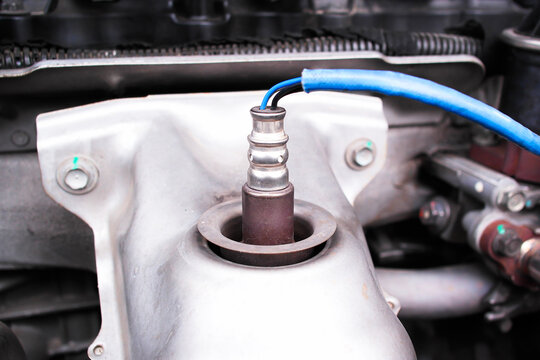 Close up of car oxygen sensor O2 sensor installed on exhaust manifold, automotive engine emission control and maintenance concept