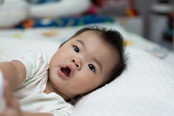 Obraz premium Adorable baby girl is lying on a bed after drinking milk