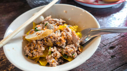Thai spicy noodle soup with minced pork and crispy fried wontons, traditional Tom Yum noodle dish