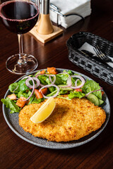 Savor a crispy schnitzel with fresh salad and zesty lemon, perfect for lunch!