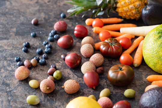 Vibrant fruits and vegetables laid out on a rustic stone table, promoting a sustainable lifestyle