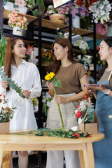 Florist women collaborating on flower arrangements in shop