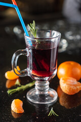A vibrant berry drink in a clear glass, garnished with herbs and fresh citrus