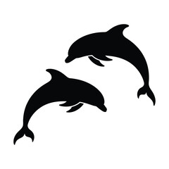 Fototapeta premium Two silhouetted dolphins leaping and swimming together in the ocean