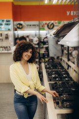 Woman Exploring Modern Cooktops in a Stylish Electronics Store
