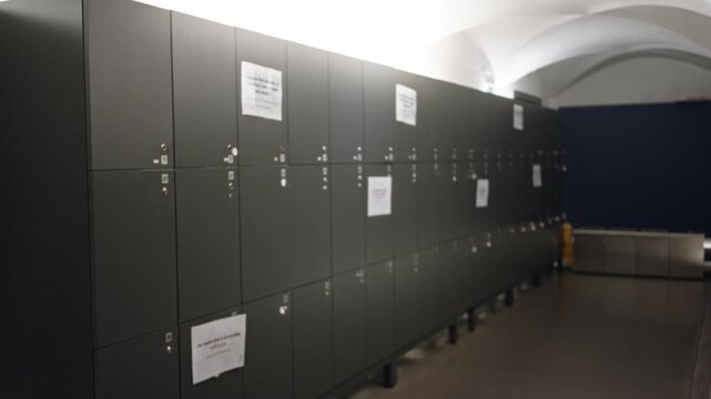 Blurred row of lockers with soft defocus in an interior corridor, shallow perspective and muted ambient light; background backplate copyspace template.