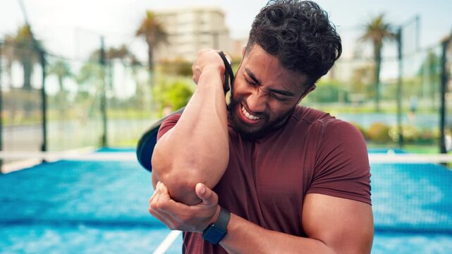 Frustrated man, padel and sport injury with elbow for pain, ache or joint inflammation in court. Active, male person or sore arm with muscle tension or strain for accident, match or outdoor game