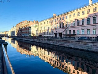 Obraz premium Saint Petersburg. A view of the Griboyedov Canal embankment on a sunny autumn morning. The buildings of the historic center are reflected in the canal's blue water. Scenic cityscape