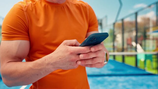 Man, hands and sport with phone in padel court for fitness app, schedule or outdoor match. Active, male person or user with mobile smartphone or chat for online network, training tips or tennis guide