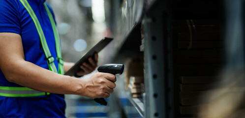A man in a blue shirt is using a barcode scanner to scan a product. Concept of efficiency and...