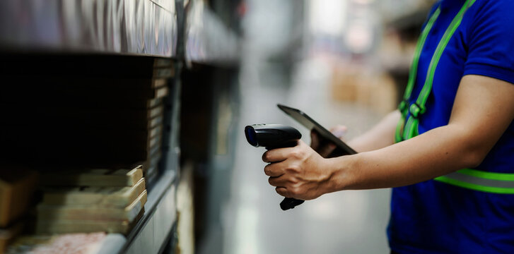A man in a blue shirt is using a barcode scanner to scan a product. Concept of efficiency and productivity, as the man is using technology to quickly and accurately identify the product