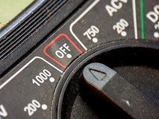 Macro image of a voltmeter showing the power switch in the off position with clear numbering.