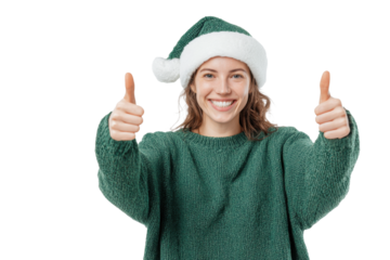 Smiling young woman in green Santa hat and matching sweater giving thumbs up gesture, cheerful Christmas portrait expressing positivity and holiday joy