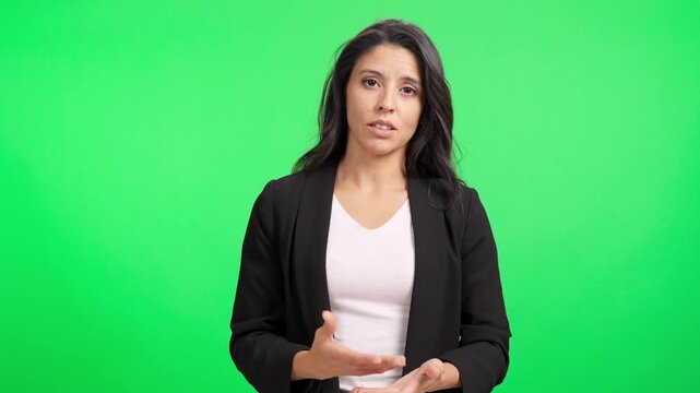 Professional hispanic woman talking to camera on green screen