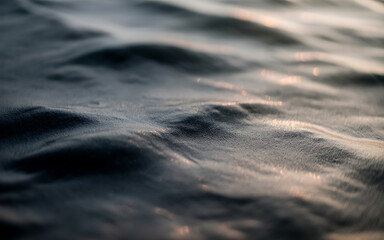 Close up of gentle waves on a body of water at sunset