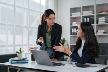 Businesswomen discussing project details in office