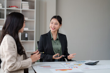 Businesswomen discussing data, collaborating on financial strategy