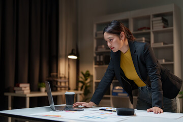 Young businesswoman analyzing financial data late at night