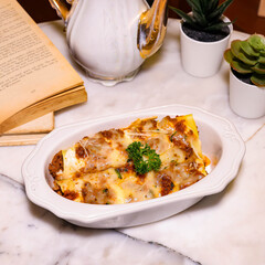 Delicious, homemade lasagna dish beautifully presented on a marble surface, alongside decorative elements