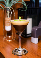 A cocktail in a classy glass, garnished with mint