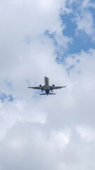 Fototapeta premium Airplane flying through a cloudy sky during the day aviation travel concept