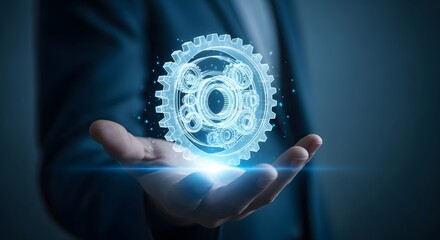 Business person hand holding glowing gear cogwheel icon on blue background industrial and technological solutions concept