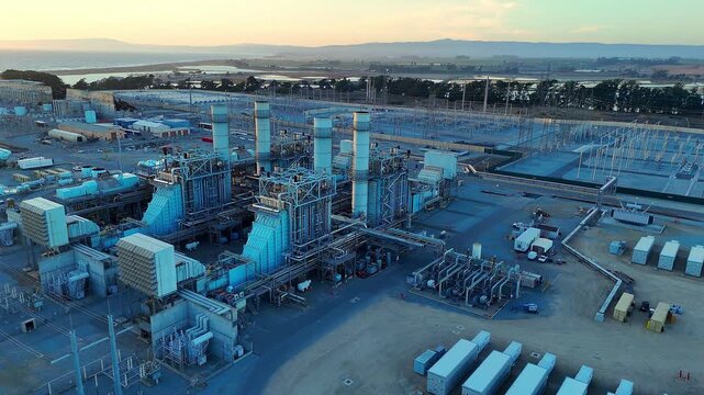 Natural gas power generation plant at Moss Landing viewed from above at dusk in conjunction with grid scale battery storage