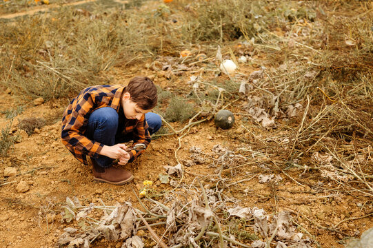 Boy sitting and using magnifying glass for observation.