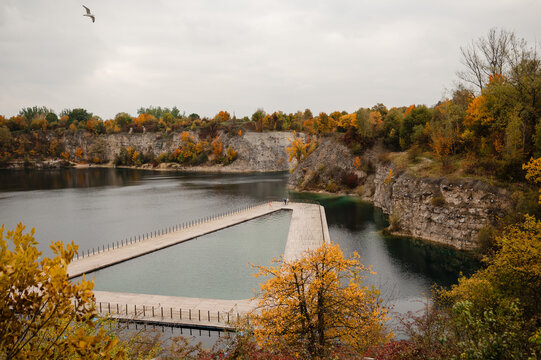 Autumn lake with wooden pier and rocky cliffs