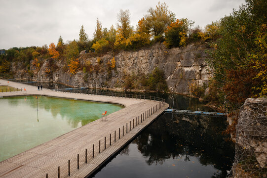 Wooden Walkway Over Pond with Autumn Foliage