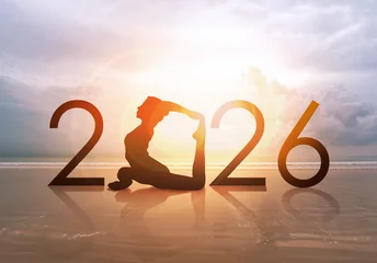 Wandcirkels Yogaschool Happy new year card 2026. Silhouette of healthy girl doing Yoga One Legged Pigeon pose on tropical beach with sunset sky background, woman practicing yoga as a part of the Number 2026 sign.  © maemanee