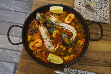 Paella pan plate with seafood and rice traditional Spanish food, close-up.