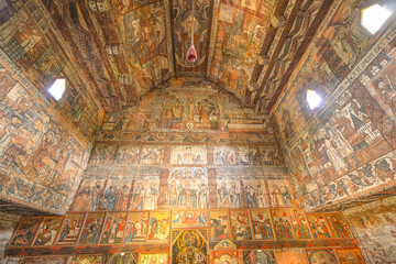 Maramures, Romania - Aug 14, 2025: Ornate frescoes covering the wood interior of the UNESCO World Heritage Site, Leud Hill Church in Maramures, Romania