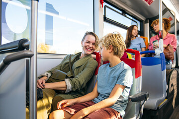 Mother and son share smiles and conversation while riding a city bus together, enjoying a cheerful...