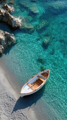 Obraz premium Minimalist Top Down Aerial View Of A Small Wooden Boat Adrift On A Shimmering Turquoise Ocean Near Rocky Shoreline On A Sunny Day