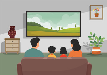 Family watching TV sitting on a couch in the living room back view