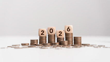 Stacks of coins with wooden blocks forming number 2026 for target financial growth, investment planning for money savings to wealth, business goals concept. Budget and tax, Happy new year 2026