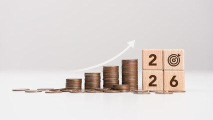 Stacks of coins with wooden blocks forming number 2026 for target financial growth, investment planning for money savings to wealth, business goals concept. Budget and tax for the year 2026.