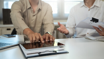 Obraz premium Closeup colleague businessman analysis business data in tablet in workplace.