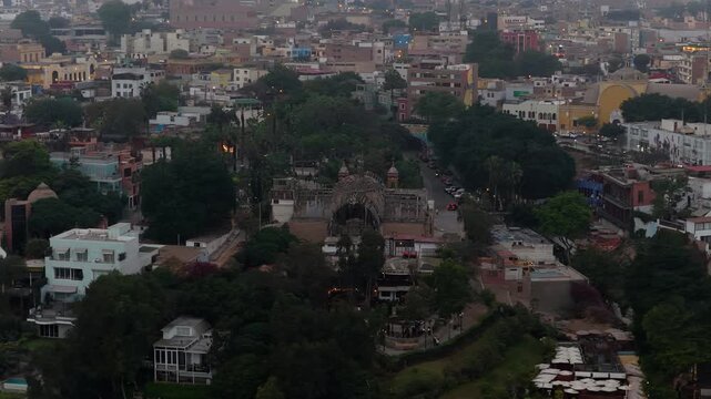 Stunning aerial footage flying over Ermita Church in bohemian Barranco district, Lima, Peru, revealing cityscape at dusk