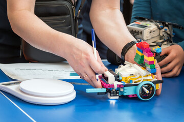 The robot constructor is preparing to be weighed on a scale