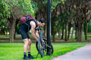 Urban cyclist locking bike for security in green park